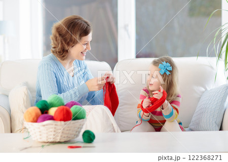 Mother and daughter knitting woolen scarf 122368271