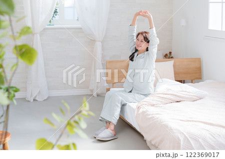 ベッドの上でストレッチするシニア女性 122369017