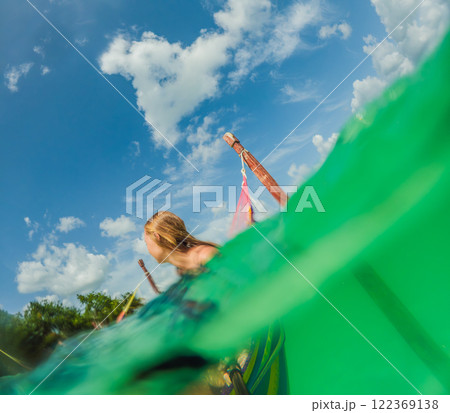 Woman tourist relaxing on a hammock above the turquoise waters of Lake Bacalar, Mexico. Peaceful retreat, tropical paradise, and relaxation concept in a serene natural setting Woman tourist relaxing on a hammock above the turquoise waters of Lake Bacalar, Mexico. Peaceful retreat, tropical paradise, and relaxation concept in a serene natural setting 122369138