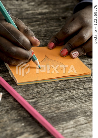 Closeup of African-American girl drawing and coloring a heart shape 122369376