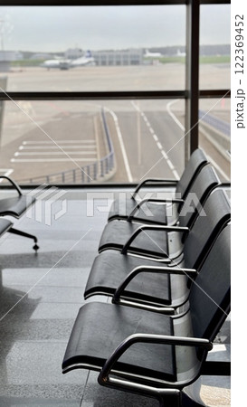 A row of stainless steel chairs in the station waiting area, each one filled with leatherette for sitting. The handrails are made of metal and steel, adding engineering touch to rectangular design A row of stainless steel chairs in the station waiting area, each one filled with leatherette for sitting. The handrails are made of metal and steel, adding engineering touch to rectangular design 122369452
