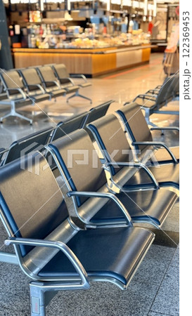 A row of stainless steel chairs in the station waiting area, each one filled with leatherette for sitting. The handrails are made of metal and steel, adding engineering touch to rectangular design A row of stainless steel chairs in the station waiting area, each one filled with leatherette for sitting. The handrails are made of metal and steel, adding engineering touch to rectangular design 122369453