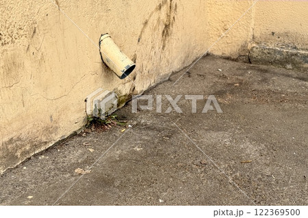 Yellow stainless steel drain pipe for drain pipe with water drainage from roof the house to the ground. It attaches to a wall of residential building 122369500