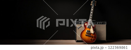 Sunburst electric guitar leaning against an amplifier in a dimly lit room, creating an inviting atmosphere for an upcoming music recording session filled with creativity and passion 122369861