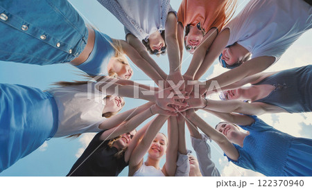 School friends come together in a circle, joining hands to represent unity, teamwork, and collaboration 122370940