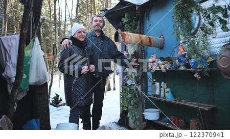 Homeless couple surviving winter near makeshift shelter, depicting harsh realities of addiction and urban poverty Homeless couple surviving winter near makeshift shelter, depicting harsh realities of addiction and urban poverty 122370941