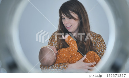 Mom cradling her infant daughter, enjoying a tender moment of bonding and love in soft, warm lighting 122371227