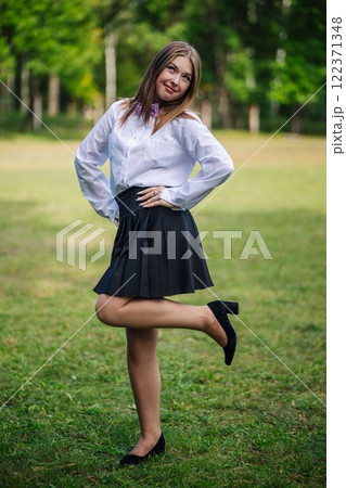 Cheerful young student smiling in a park, savoring her return to school after the summer break Cheerful young student smiling in a park, savoring her return to school after the summer break 122371348