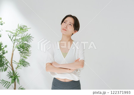 ヨガウェアをきて腕組みをする30代女性 122371993