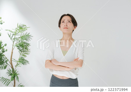 ヨガウェアをきて腕組みをする30代女性 122371994