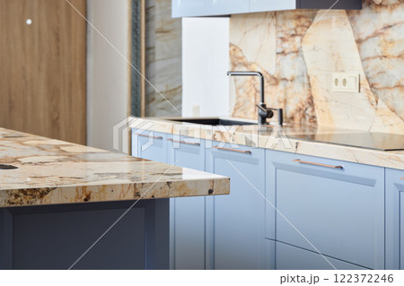 A modern kitchen with blue cabinets and marble countertops, blending luxury and functionality A modern kitchen with blue cabinets and marble countertops, blending luxury and functionality 122372246