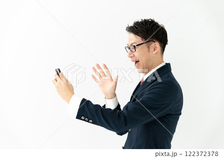 スマホを見て喜ぶビジネスマン 122372378