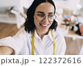 Happy woman in eyeglasses with tape measure 122372616