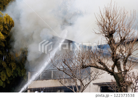 住宅火災の消火作業、放水と煙 122373538