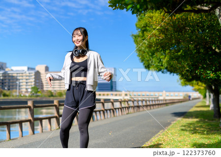 川沿いの歩道で手足ぶらぶらのストレッチをするかっこいい女性 歩く ダイエット 散歩 運動 川沿いの歩道で手足ぶらぶらのストレッチをするかっこいい女性 歩く ダイエット 散歩 運動 122373760