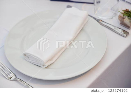 An Elegant Table Setting Featuring a White Napkin and a Beautifully Styled Plate 122374192