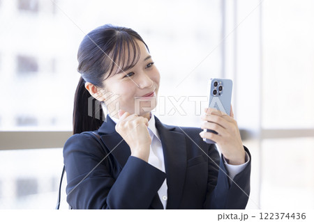 就活 スマホを見ながら喜ぶ女性 就活 スマホを見ながら喜ぶ女性 122374436