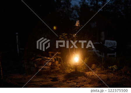 A Beautifully Illuminated Lantern in a Calm and Serene Night Garden Setting Surrounded by Nature A Beautifully Illuminated Lantern in a Calm and Serene Night Garden Setting Surrounded by Nature 122375500