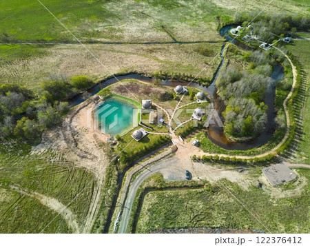 An Aerial View showcasing a Beautiful Rustic Retreat complete with a Healing Pond and Cozy Cabins 122376412