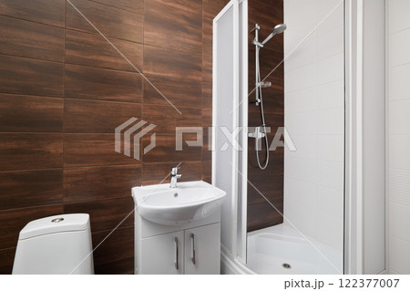 This modern bathroom features a sleek shower and stylish wood panel walls, creating elegance 122377007