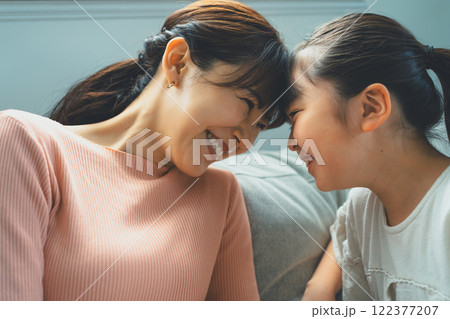 おでことおでこをくっつける9歳の娘とママ 122377207