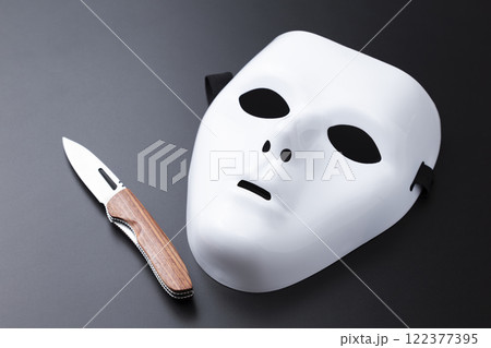 黒背景に仮面とナイフ 122377395