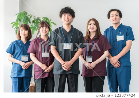 スクラブを着た医師・介護士・整体師の男女 122377424