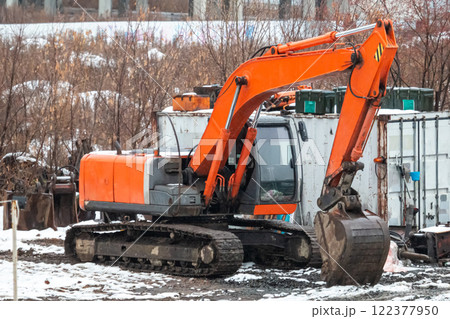 Orange crawler excavator at a construction site at winter Orange crawler excavator at a construction site at winter 122377950