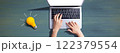Person using a laptop computer and a light bulb 122379554