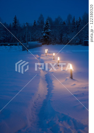 A Serene Winter Pathway Beautifully Illuminated by Lanterns in the Soft Snowfall A Serene Winter Pathway Beautifully Illuminated by Lanterns in the Soft Snowfall 122380320