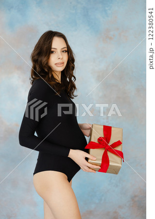 Elegant woman in black holding a gift box 122380541