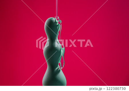 Lube pouring onto green anal beads on pink background. Lube pouring onto green anal beads on pink background. 122380730