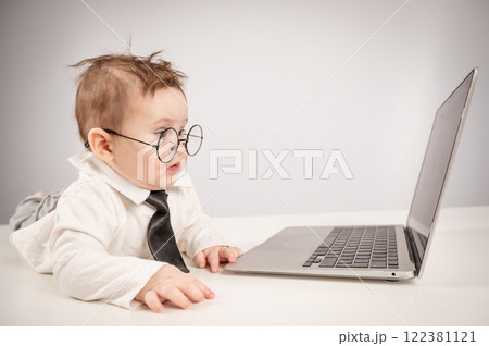 Cute baby in glasses and suit working on laptop. Cute baby in glasses and suit working on laptop. 122381121