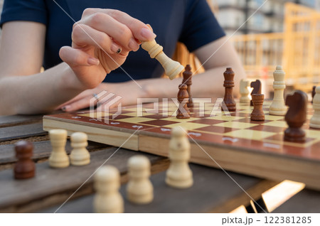 Close-up of female hands at chessboard. Close-up of female hands at chessboard. 122381285