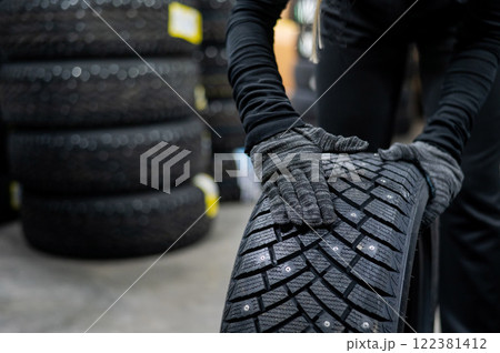 Mechanic keeps new studded car tires in garage.  Mechanic keeps new studded car tires in garage.  122381412