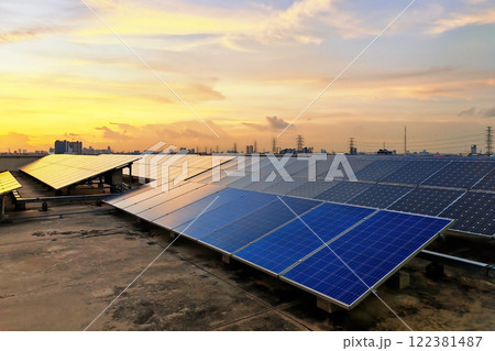 Solar panels on roof of office building against sunset sky Solar panels on roof of office building against sunset sky 122381487