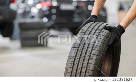 Man holding old car tire. Close up of mechanic's hands with wheel.  122381627