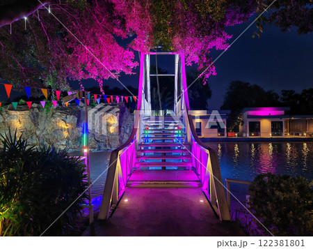 Colorful light up decoration on bridge and trees at hotel pool 122381801