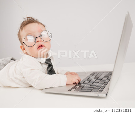 Cute baby in glasses and suit working on laptop.  122381831