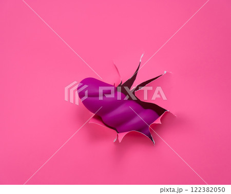 Raspberry sex toy sticks out of pink paper background. Raspberry sex toy sticks out of pink paper background. 122382050