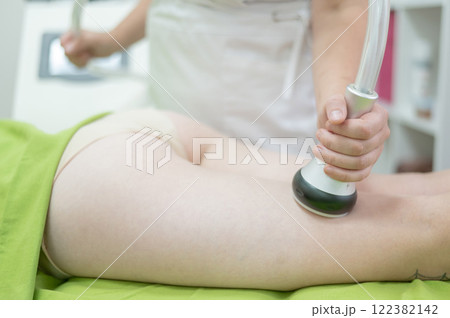 Caucasian woman on hardware anti-cellulite massage. Thigh cavitation procedure. Caucasian woman on hardware anti-cellulite massage. Thigh cavitation procedure. 122382142