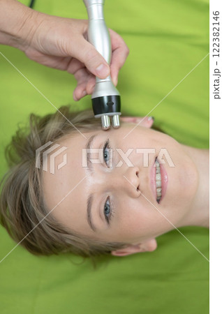 Top view of Caucasian woman undergoing radio wave RF lifting procedure in beauty salon. Top view of Caucasian woman undergoing radio wave RF lifting procedure in beauty salon. 122382146