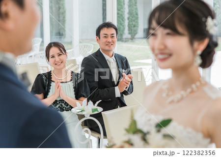 結婚式で拍手をして祝う笑顔のゲスト・出席者・参列者・友人の男女 122382356