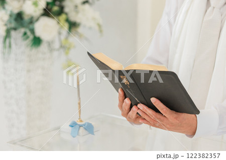 チャペル・教会で聖書を持つ神父の手元（結婚式・ウェディング・教会） 122382357