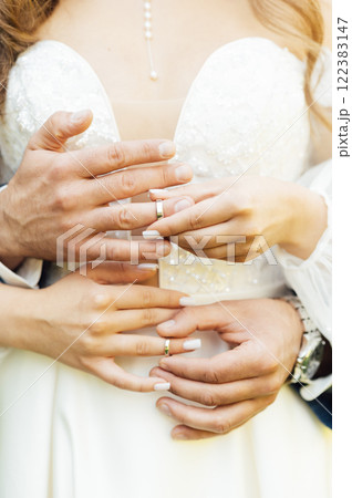 two gold wedding rings. the bride wears the groom wedding ring. newlyweds with rings on fingers. 122383147