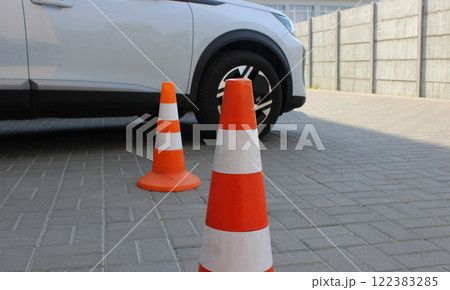 Two cones indicate reserved parking space at the parking lot. Parking cones stock photo 122383285