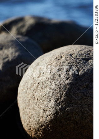 A Detailed and CloseUp View of Smooth Natural Rocks Situated by the Waters Edge 122383896