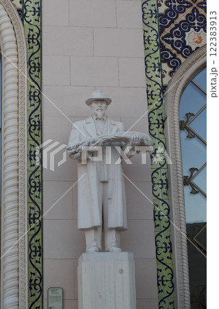 An Elegant White Statue Gracefully Positioned Against a Beautifully Decorative Wall 122383913