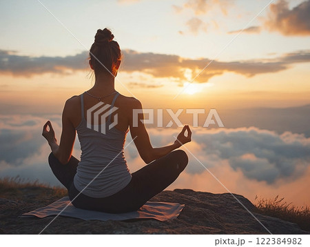 Person practicing yoga in a serene outdoor location at sunrise Person practicing yoga in a serene outdoor location at sunrise 122384982