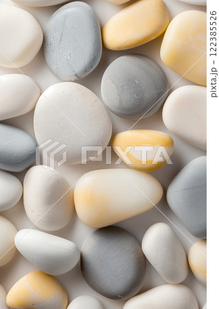 Top view of smooth beige, gray, and yellow pebbles creating a natural background 122385526